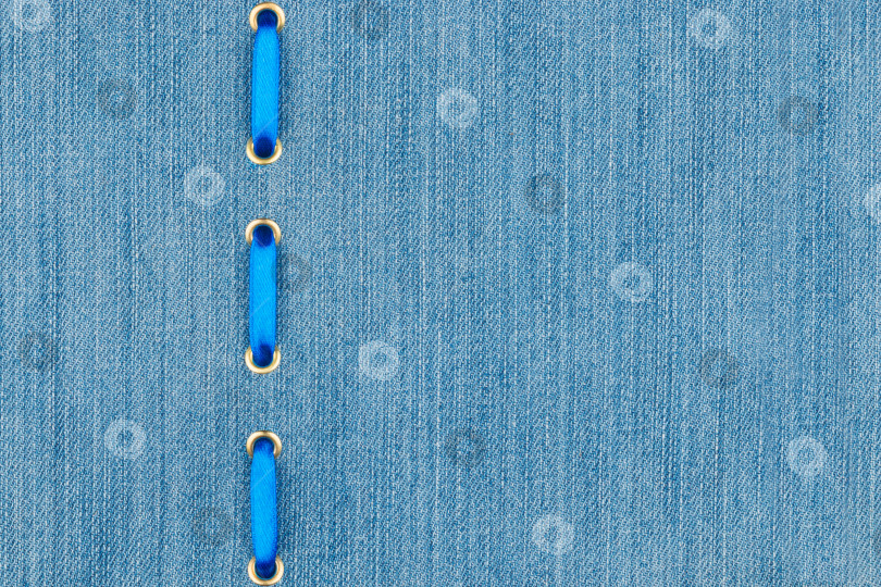 Скачать Модный фон, синяя атласная лента, вставленная в джинсовую ткань фотосток Ozero