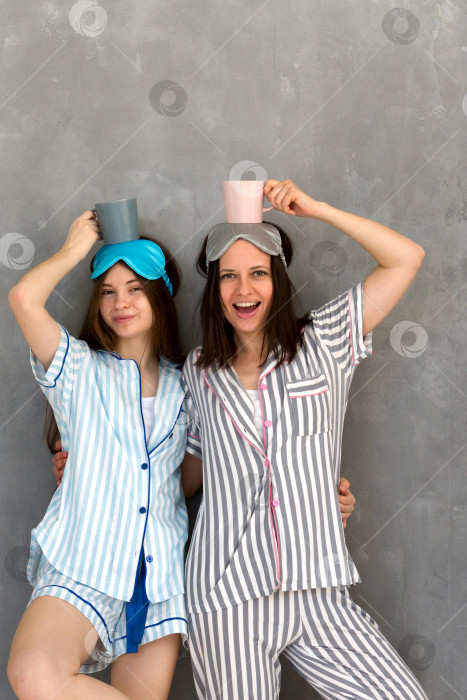 Скачать Мать и дочь в пижамах играют в эквилибристическую игру на вечеринке с ночевкой. фотосток Ozero