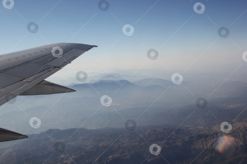 Скачать Крыло самолета над горной местностью фотосток Ozero