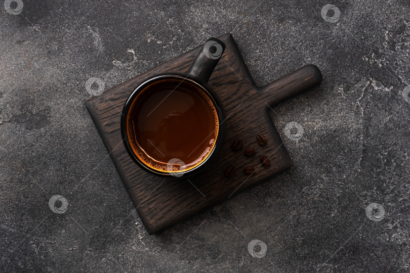 Скачать Черный кофе в чашке и кофейные зерна на темном фоне. Вид сверху на пространство для копирования. фотосток Ozero
