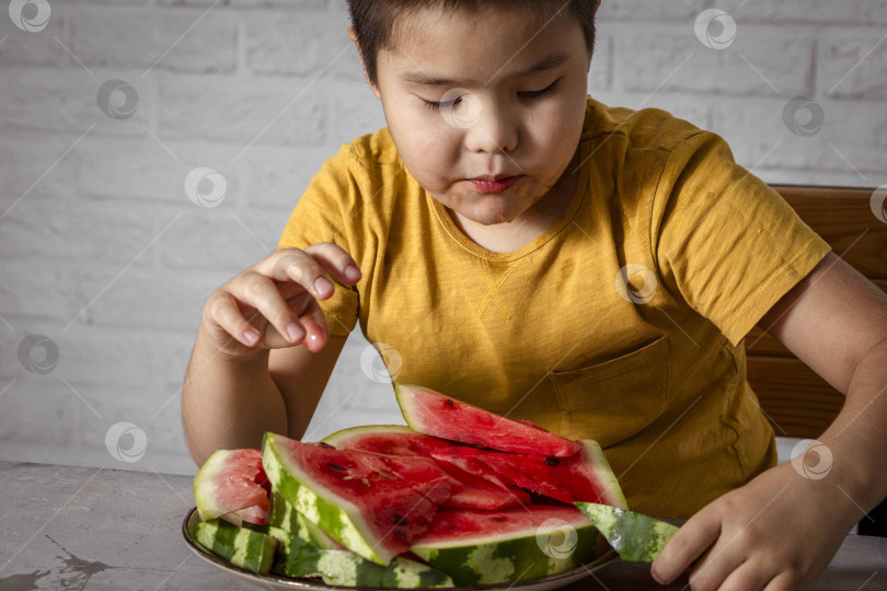 Скачать мальчик ест арбуз - яркий и богатый источник витамина С фотосток Ozero