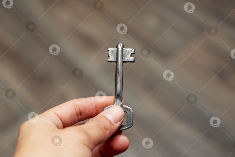 Скачать Человек, держащий в руке маленький ключик из никеля фотосток Ozero