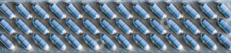 Скачать Светло-голубые таблетки упакованы рядами в длинный прозрачный блистер, который занимает весь фон. Медицинская справка для промышленности, бизнеса, аптек, клиник. фотосток Ozero
