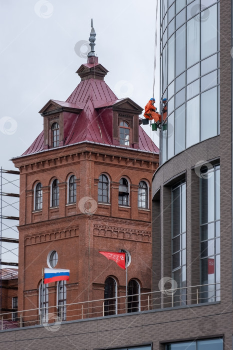 Скачать Санкт-Петербург, Россия - 10 мая 2024 года. Промышленный альпинист моет окна. фотосток Ozero