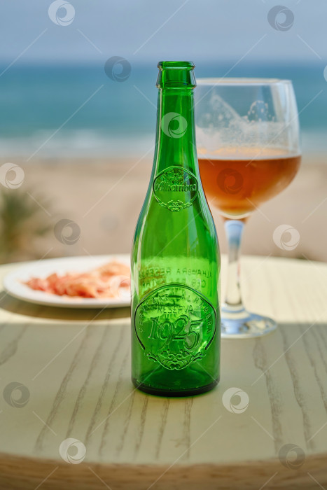 Скачать Валенсия, Испания - 07 мая 2019 года : Бутылка и бокал пива на столе. фотосток Ozero