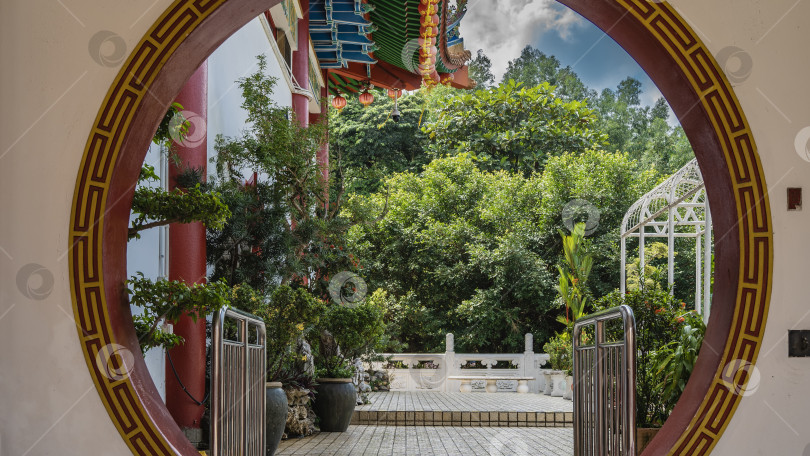 Скачать Через закругленный дверной проем виден внутренний двор храма Кек Лок Си. фотосток Ozero