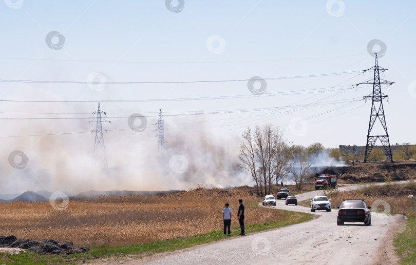 Скачать Возгорание сухой травы и камыша вблизи жилых зданий. фотосток Ozero