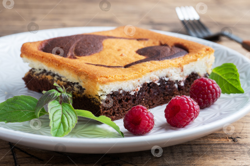 Скачать Кусочек двухслойного торта на тарелке с шоколадным брауни и творожным чизкейком с малиной. скопировать через пробел фотосток Ozero