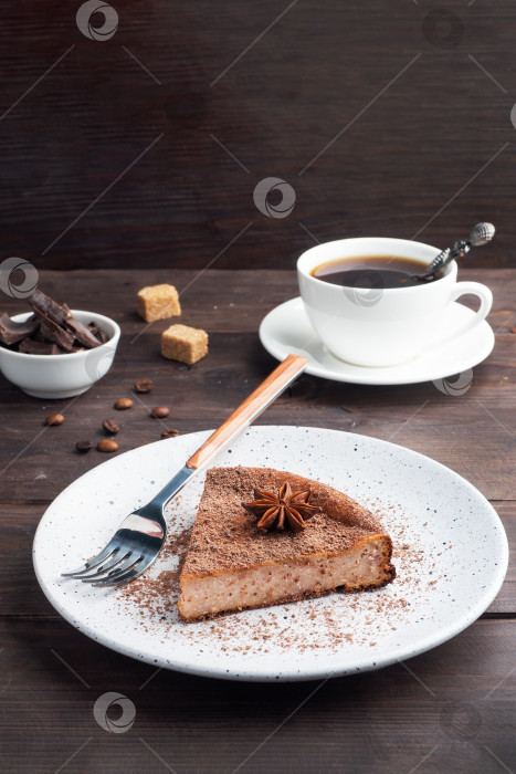 Скачать Кусочек шоколадно-творожной запеканки на тарелке, порционный кусок торта с шоколадом и кофе. Деревенский фон из темного дерева. пространство для копирования фотосток Ozero