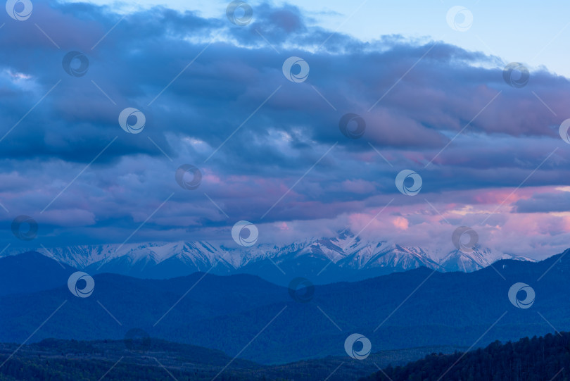 Скачать Прекрасный красочный закат над заснеженным горным хребтом и сосновым лесом. фотосток Ozero