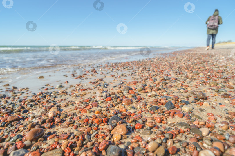 Скачать человеческая фигура на каменистом пляже на размытом фоне фотосток Ozero