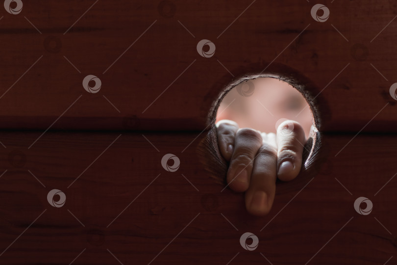 Скачать Вид маленького мальчика через дыру в деревянном заборе фотосток Ozero