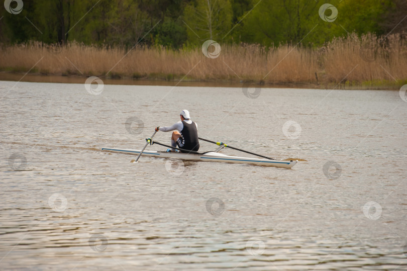 Скачать спортсмен на лодке тренируется гребле на реке в Калининграде фотосток Ozero