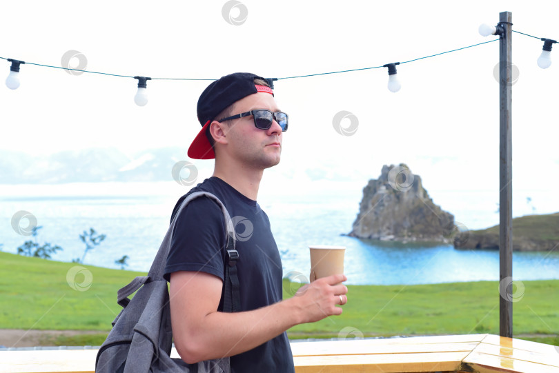Скачать Российский турист пьет чай у священного места шаманов Шаманка. Озеро Байкал, Ольхон. фотосток Ozero