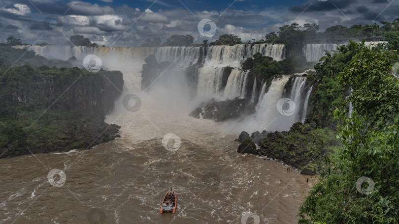 Скачать Туристический катер мчится по руслу бурной реки к водопаду. фотосток Ozero