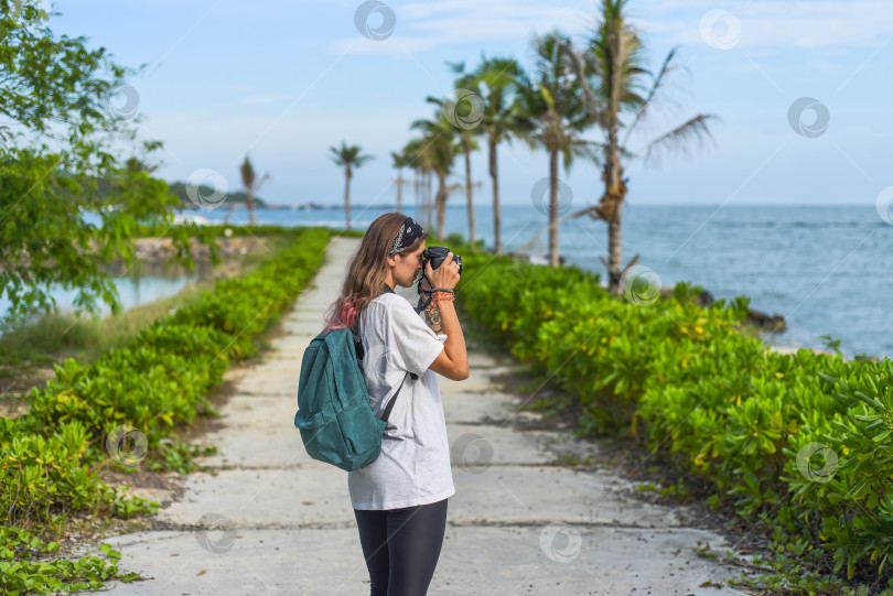 Скачать Симпатичный фотограф и блогер-путешественник, фотографирующий на камеру летом фотосток Ozero