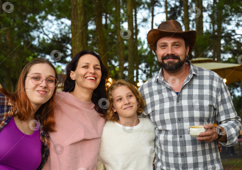 Скачать Члены семьи - отец, мать и две дочери - смеются в походе в лесу фотосток Ozero