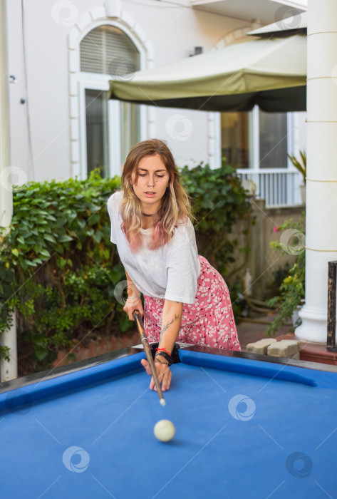Скачать Молодая блондинка играет в бильярд на заднем дворе фотосток Ozero