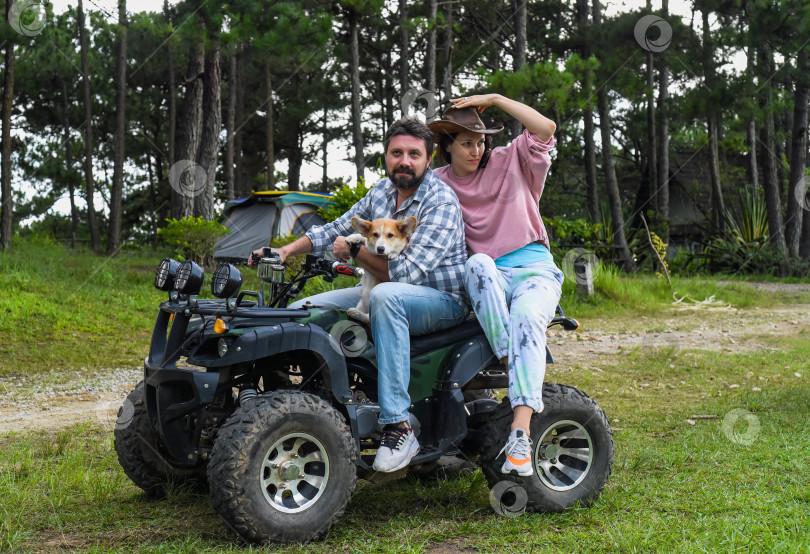Скачать Портрет молодой супружеской пары, сидящей на квадроцикле в лесу фотосток Ozero