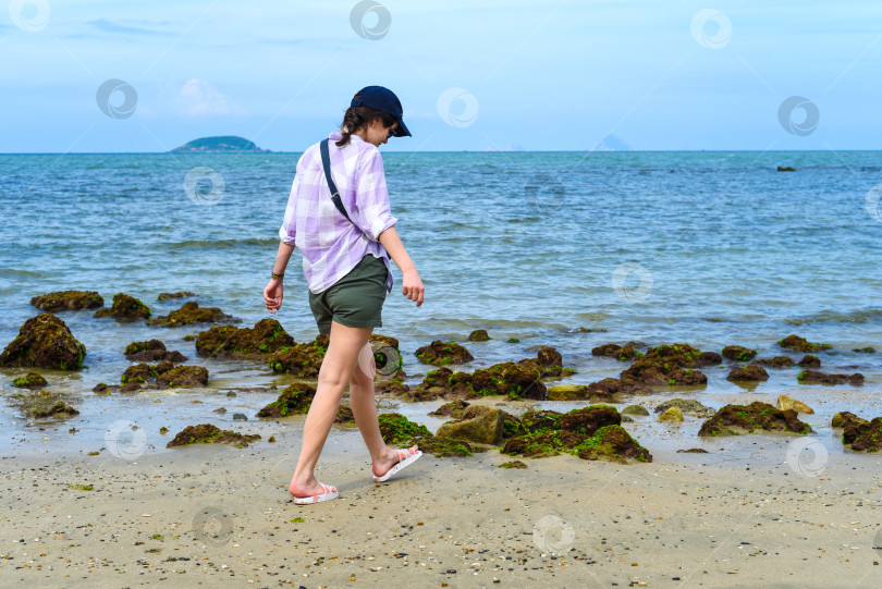 Скачать Молодая стройная женщина прогуливается по пляжу Южно-Китайского моря в Нячанге, Вьетнам фотосток Ozero