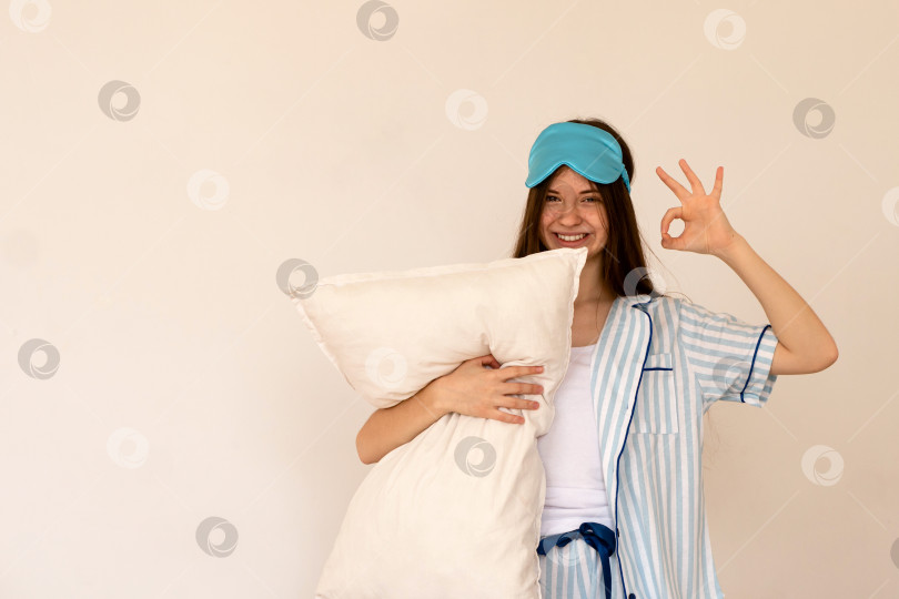 Скачать Счастливая девочка-подросток держит подушку и делает знак мира фотосток Ozero
