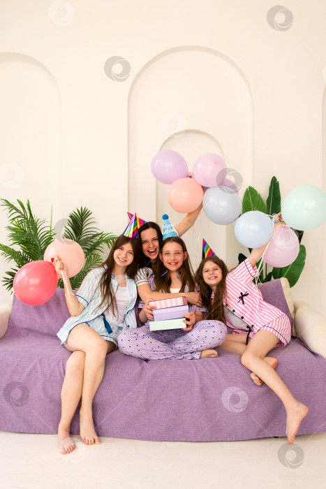 Скачать Семья празднует день рождения с воздушными шарами и подарками на диване фотосток Ozero