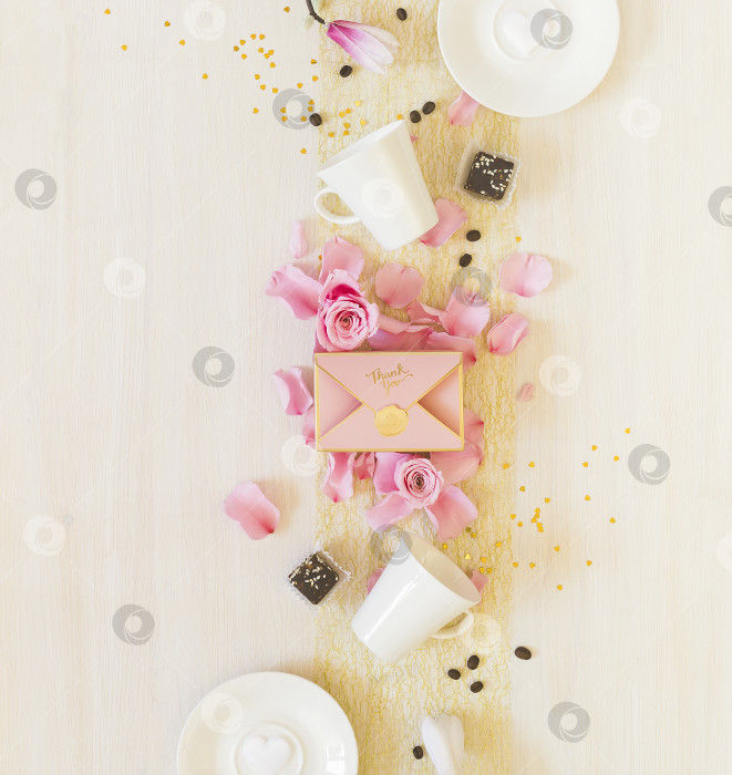 Скачать Натюрморт с чашками кофе, сладостями, подарочной коробкой и лепестками роз на белом фоне фотосток Ozero