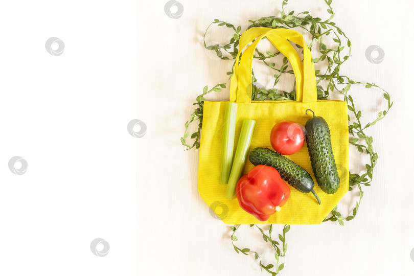 Скачать Хлопчатобумажный пакет с сезонными овощами для салата на белом деревянном фоне фотосток Ozero