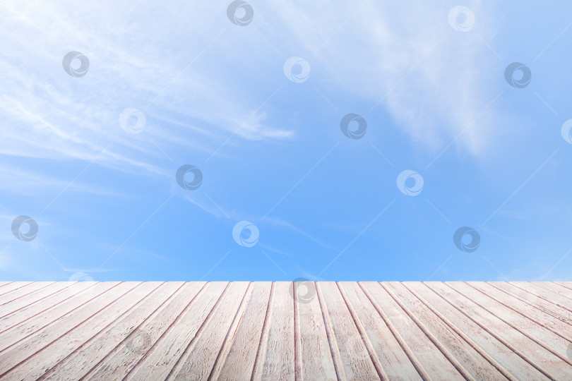 Скачать Перспективный вид на деревянную столешницу на фоне ярко-голубого неба фотосток Ozero