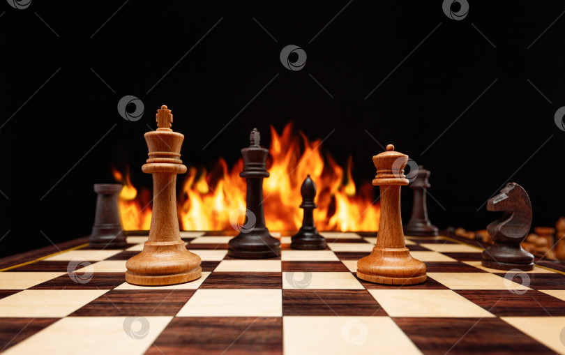 Скачать Шахматные фигуры на шахматной доске в огне. фотосток Ozero