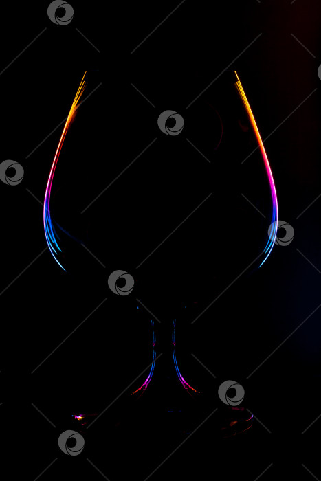 Скачать Абстрактный вид на силуэт винного бокала с подсвеченными разноцветными градиентными краями на черном фоне (концепция, пространство для копирования) фотосток Ozero