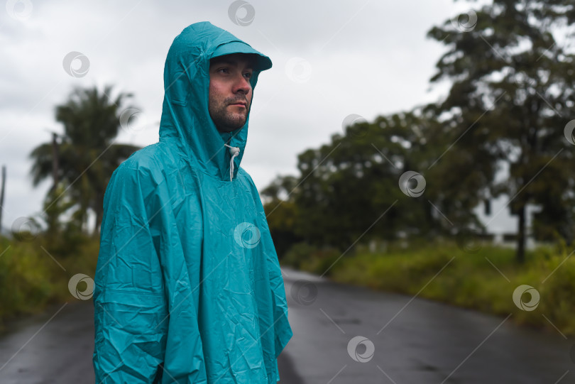 Скачать Депрессивный концепт с одиноким мужчиной в плаще, стоящим на мокрой дороге под дождем крупным планом фотосток Ozero