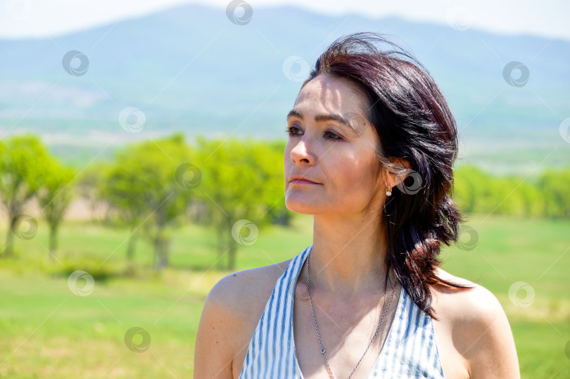 Скачать Портрет 45-летней русской женщины, улыбающейся и смотрящей в сторону на фоне поля. фотосток Ozero