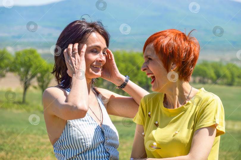 Скачать Две русские женщины разговаривают друг с другом и искренне смеются, обнажая зубы. фотосток Ozero