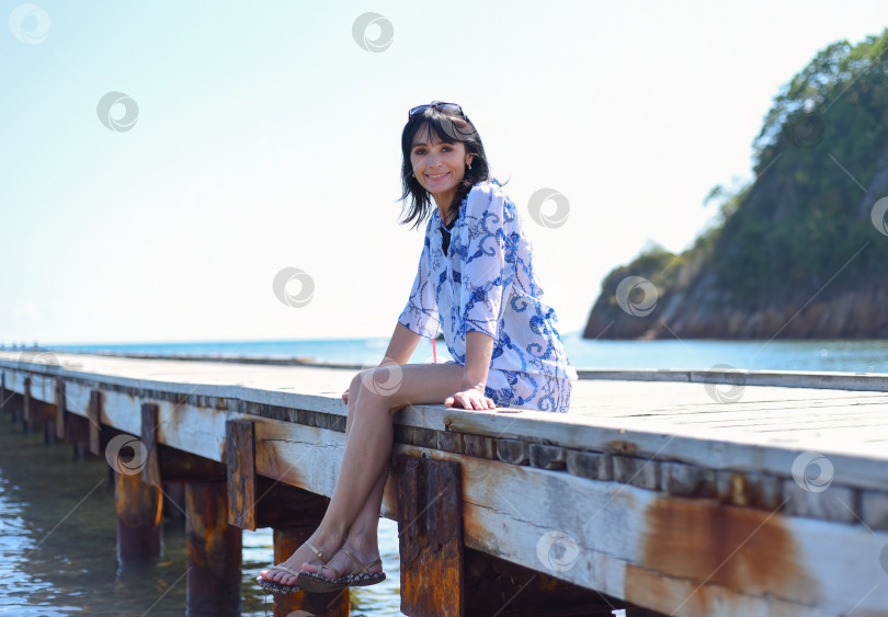Скачать 45-летняя русская женщина улыбается и смотрит вперед на фоне Японского моря фотосток Ozero