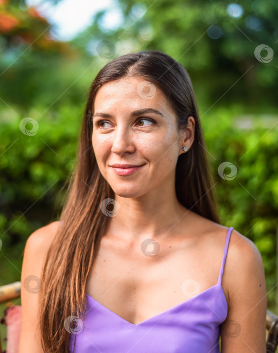 Скачать Портрет русской молодой женщины с длинными волосами на фоне зеленых листьев фотосток Ozero