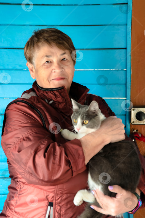 Скачать Старая русская женщина держит на руках свою кошку и улыбается фотосток Ozero
