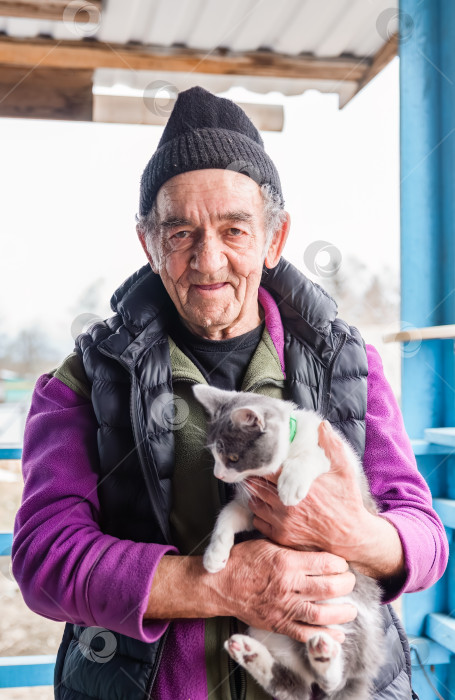 Скачать Старый русский мужчина держит на руках свою кошку и улыбается фотосток Ozero