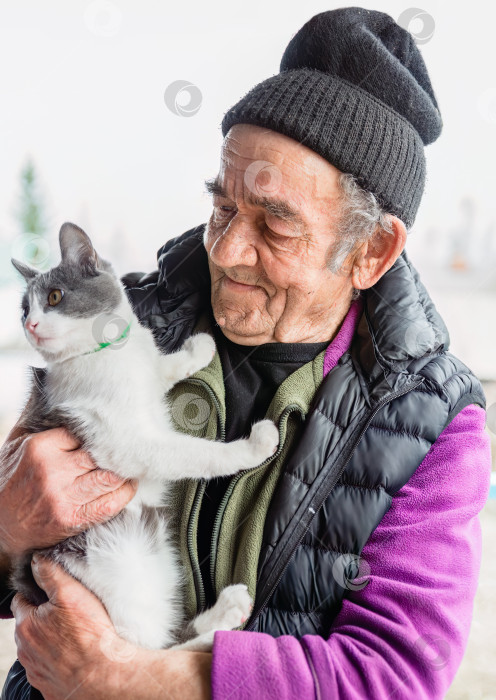 Скачать Старый русский мужчина держит на руках свою кошку и улыбается фотосток Ozero