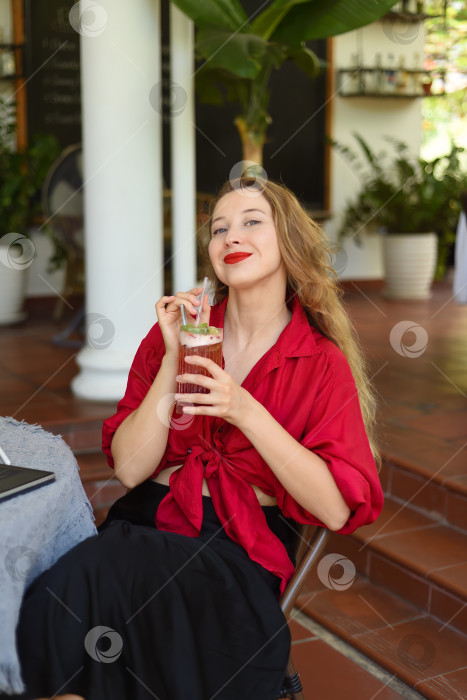 Скачать Русская красивая блондинка пьет клубничный чай через соломинку и смотрит в камеру фотосток Ozero