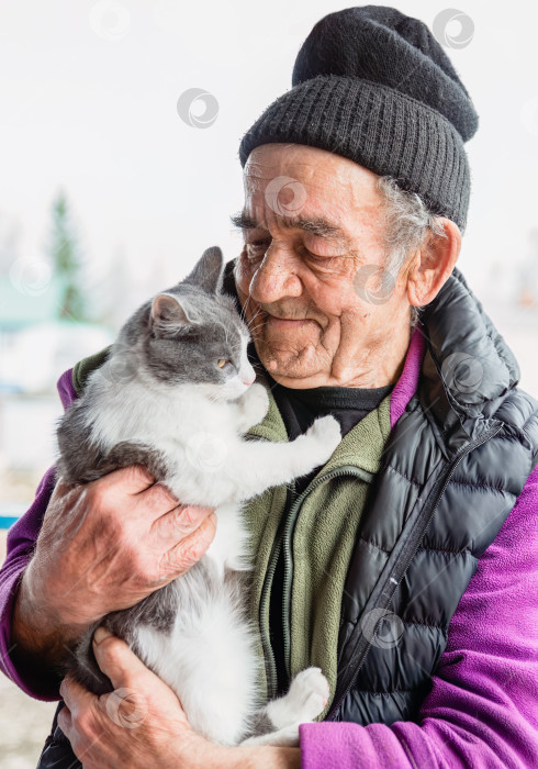 Скачать Старый русский мужчина держит на руках свою кошку и улыбается фотосток Ozero