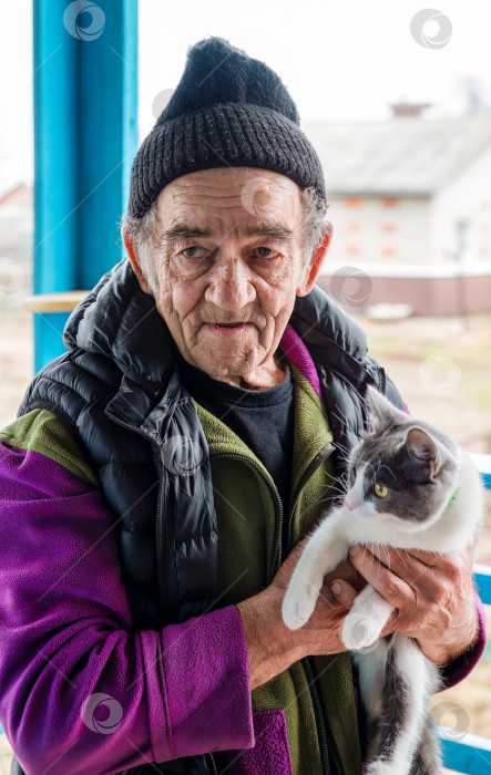 Скачать Старый русский мужчина держит на руках свою кошку и улыбается фотосток Ozero