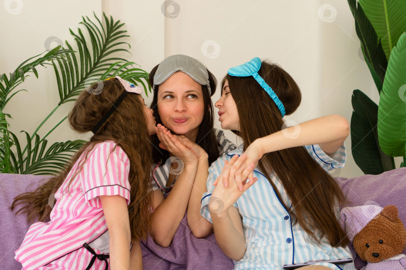 Скачать Мать, получающая поцелуи от своих дочерей дома. фотосток Ozero