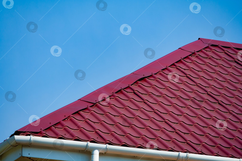 Скачать Фрагмент фиолетовой металлочерепичной крыши на фоне голубого неба фотосток Ozero