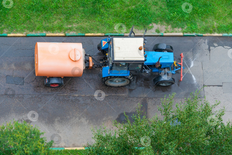 Скачать Вид сверху на трактор с баком для мытья асфальтированной дороги в парке фотосток Ozero