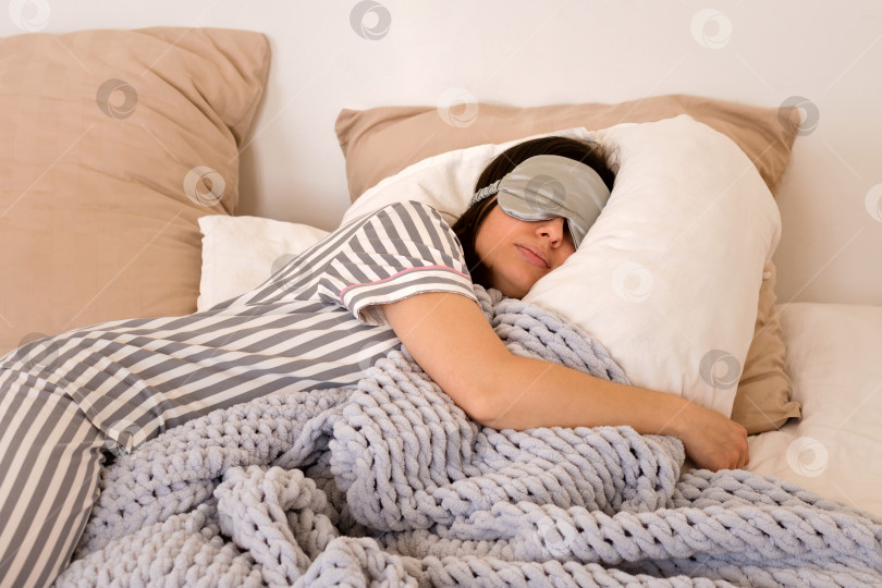 Скачать Женщина крепко спит с маской на глазах в уютной постели. фотосток Ozero