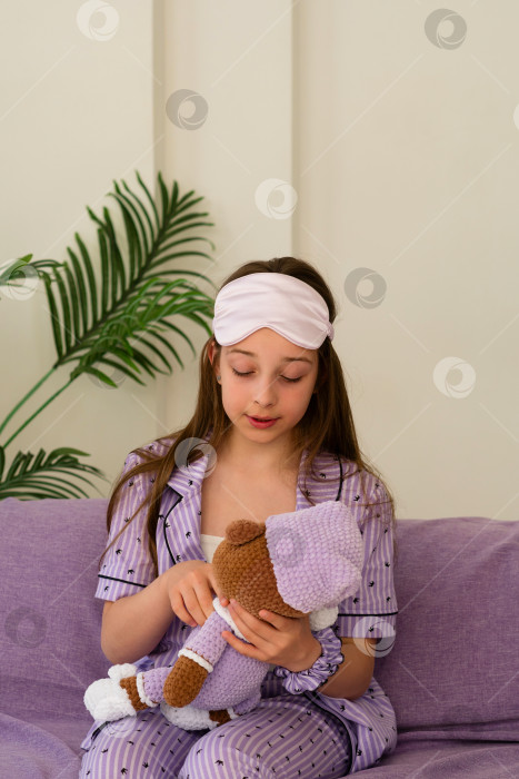 Скачать Девушка на диване с нежностью смотрит на плюшевого мишку. фотосток Ozero
