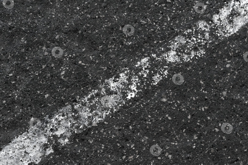 Скачать Потертая белая диагональная линия на темном шероховатом асфальте (абстракция, фон, текстура) фотосток Ozero