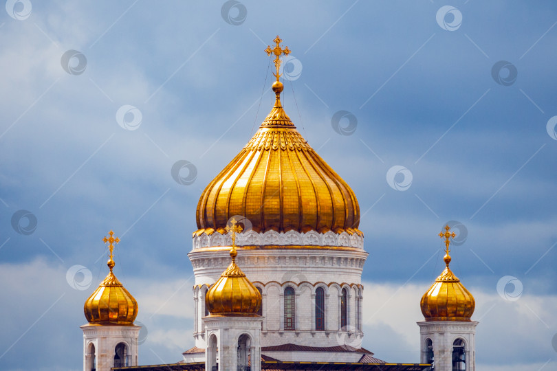 Скачать Крупный план позолоченных куполов храма Христа Спасителя в Москве (Россия) на фоне драматического облачного неба фотосток Ozero