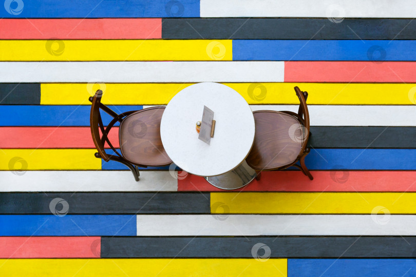 Скачать Вид сверху на круглый стол и стулья на разноцветном деревянном полу в кафе фотосток Ozero